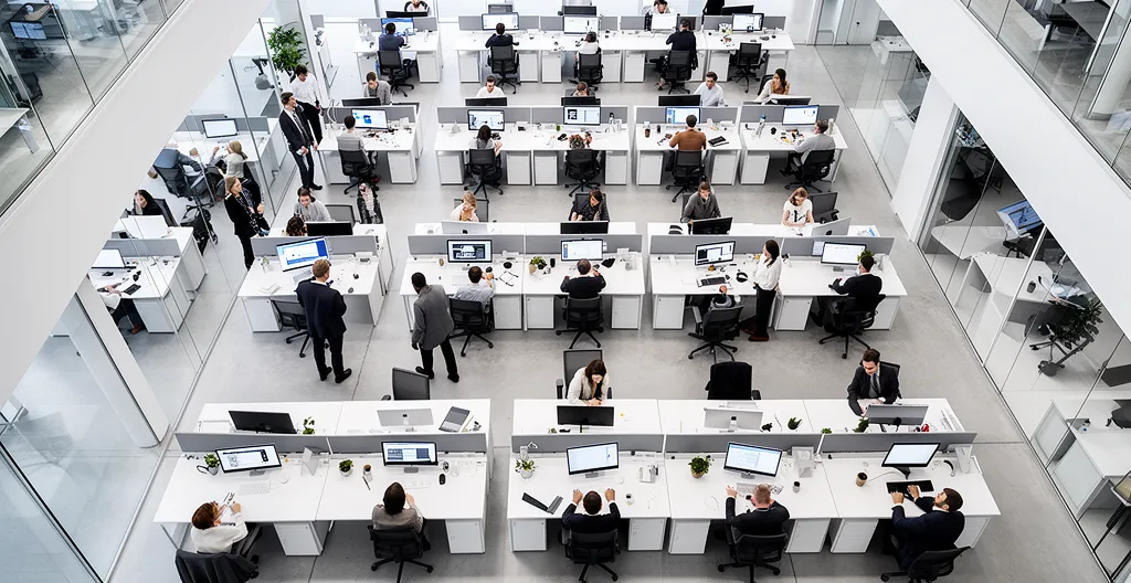 Vue aérienne d'un open space moderne avec équipes collaborant autour de tableaux stratégiques