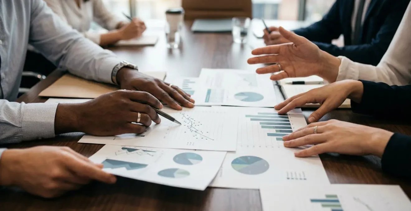 Mains d'entrepreneurs et investisseurs autour d'une table de négociation avec documents financiers